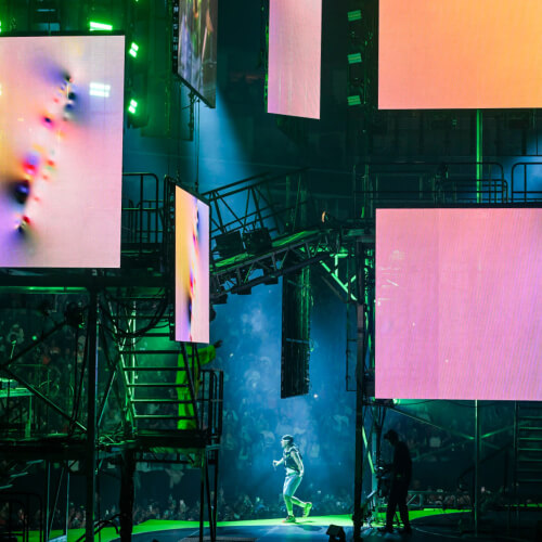 Large LED screens showing artowrks at concert.