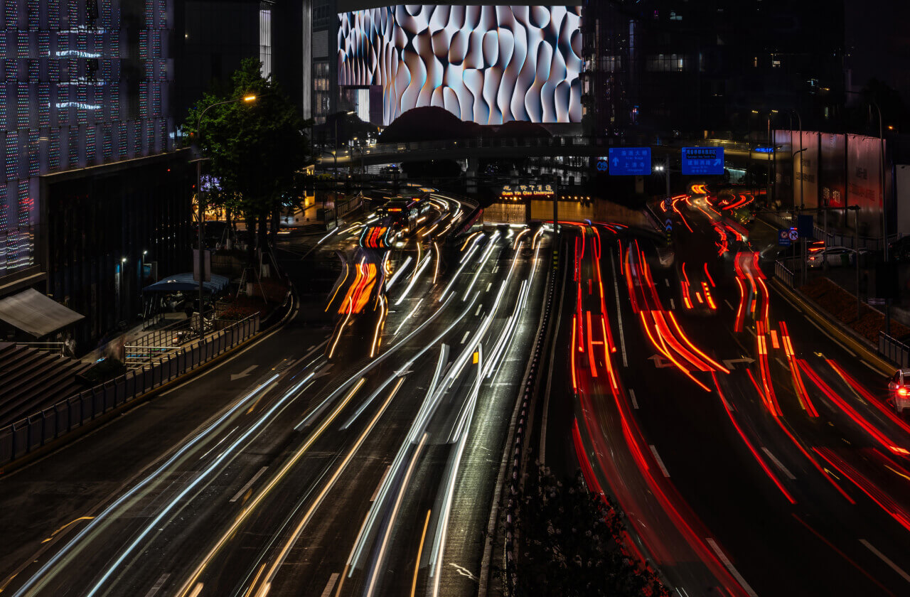 Shot from afar capturing the freeway and traffic lights, with the artwork displayed in the top center of the image.