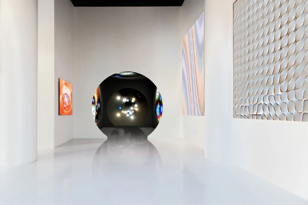 Another angle of the white gallery showcasing the artist's work on LED screens, with a spacious, open feel.